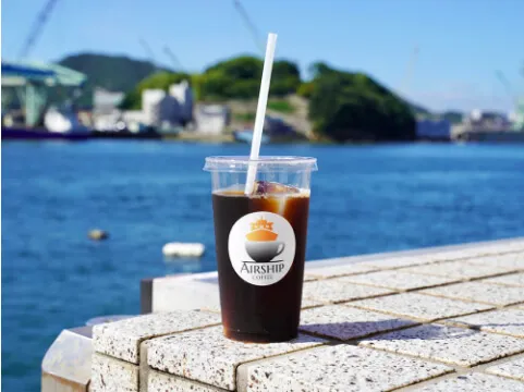 写真:海を背景にアイスコーヒー